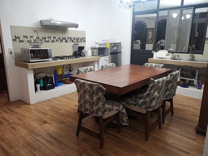 Comedor de madera con la cocina al fondo