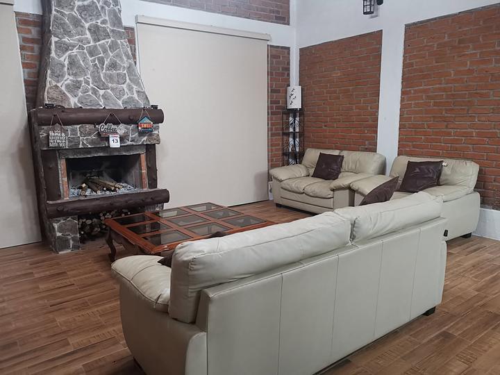 Sala con sillones y chimenea de piedra