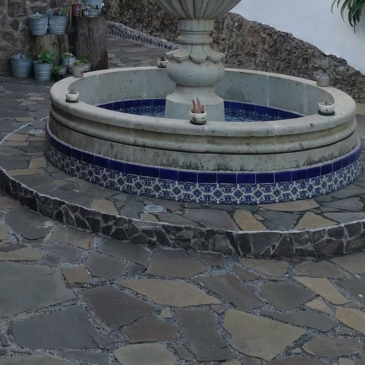 Base de la fuente con azulejo de talavera azul sobre piso de piedra