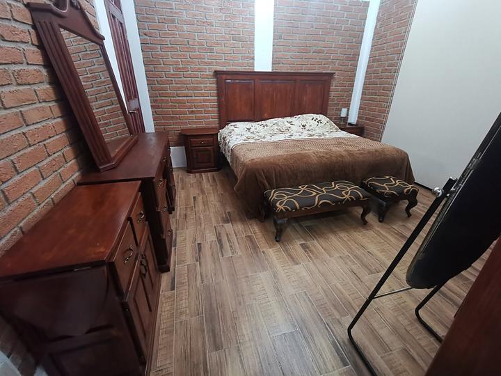 Recámara con cama y muebles de madera