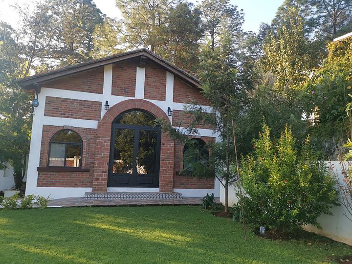 Fachada de ladrillo con arcos, vista desde el pasto