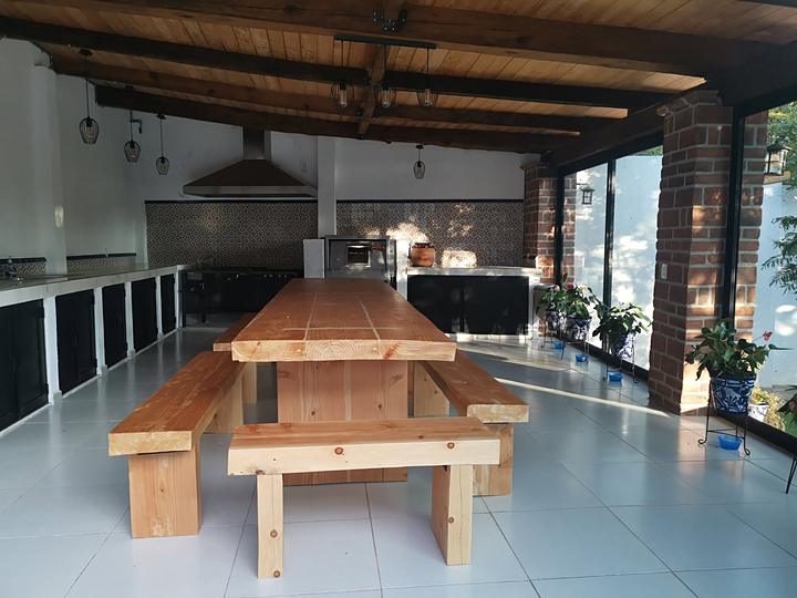 Terraza cocina con mesa larga de madera y bancas